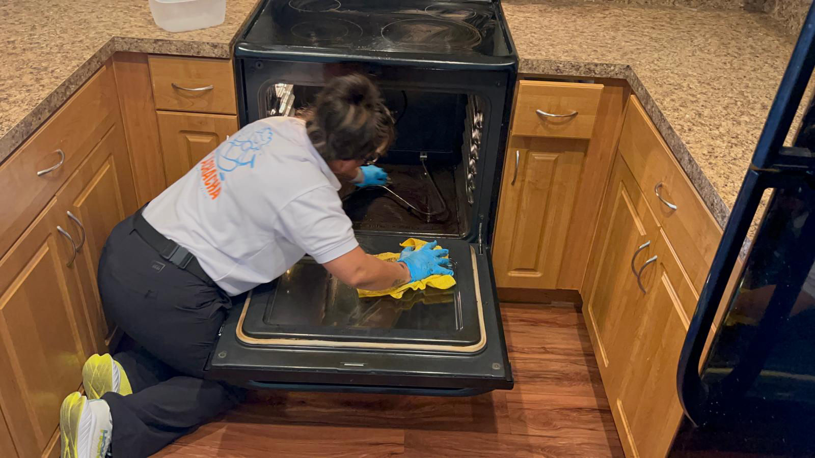 A La Chacha Cleaning team member deep-cleaning a kitchen oven